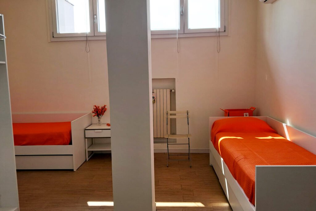 comodi letti singoli a creare piccoli spazi di privacy nella mansarda condivisa